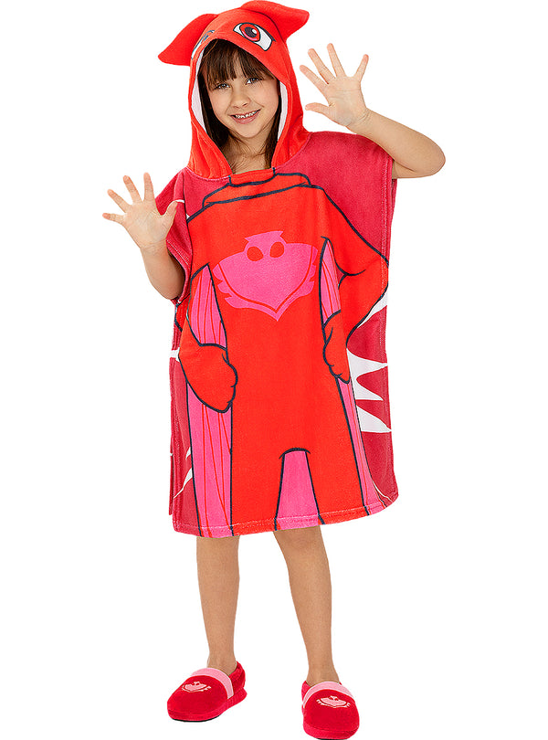 Mergaitė su raudonu „PJ Masks“ Owlette pončo rankšluosčiu ir gobtuvu.