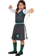 Mergaitė su „Slytherin“ uniforma, pilku sijonu, liemene ir burtų lazdele.