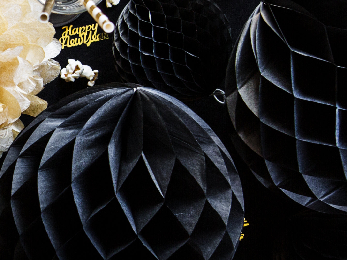 Black honeycomb decorations with gold 'Happy New Year!' text on a dark background