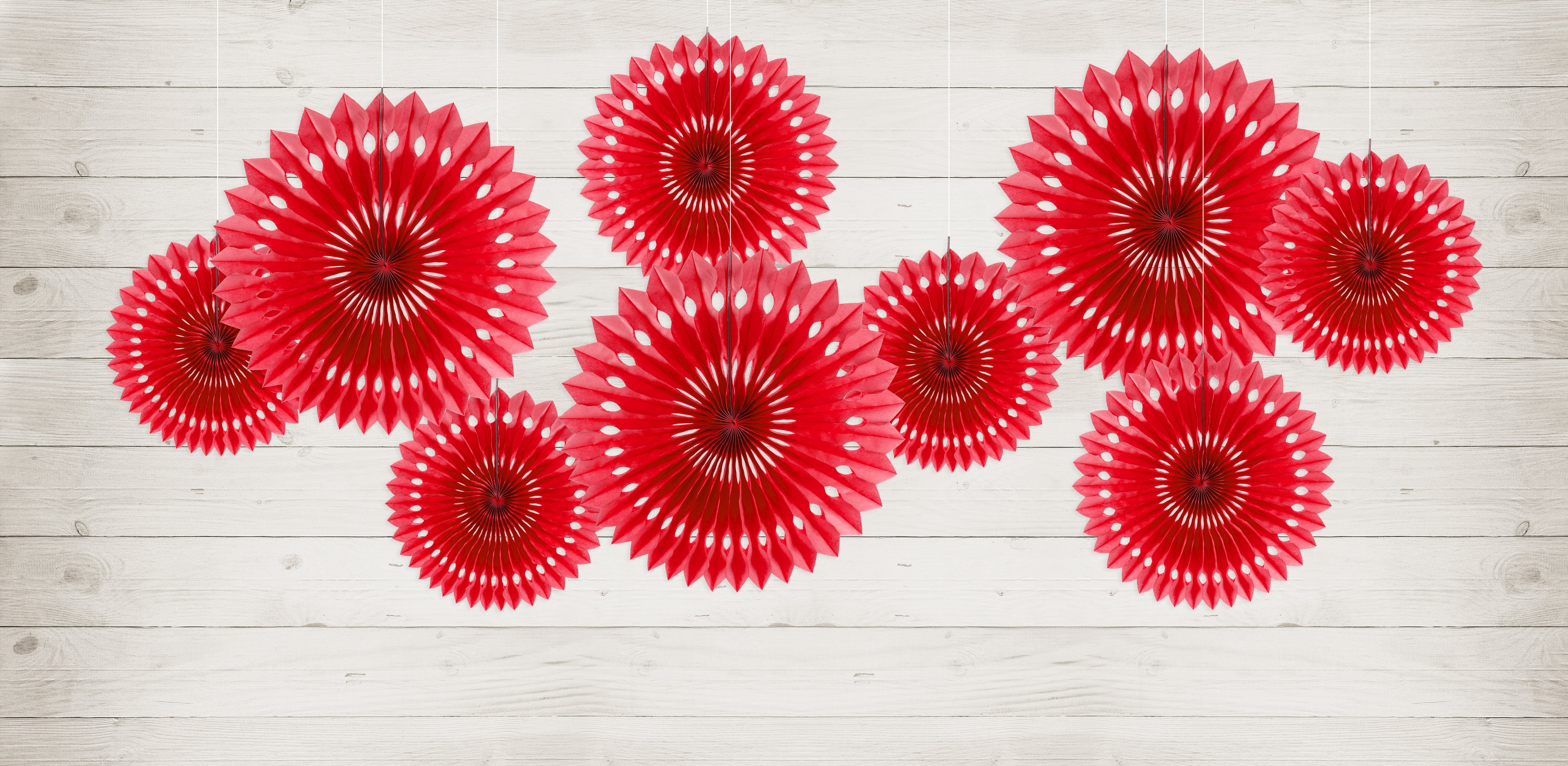 Red paper fan decorations on a light wooden background