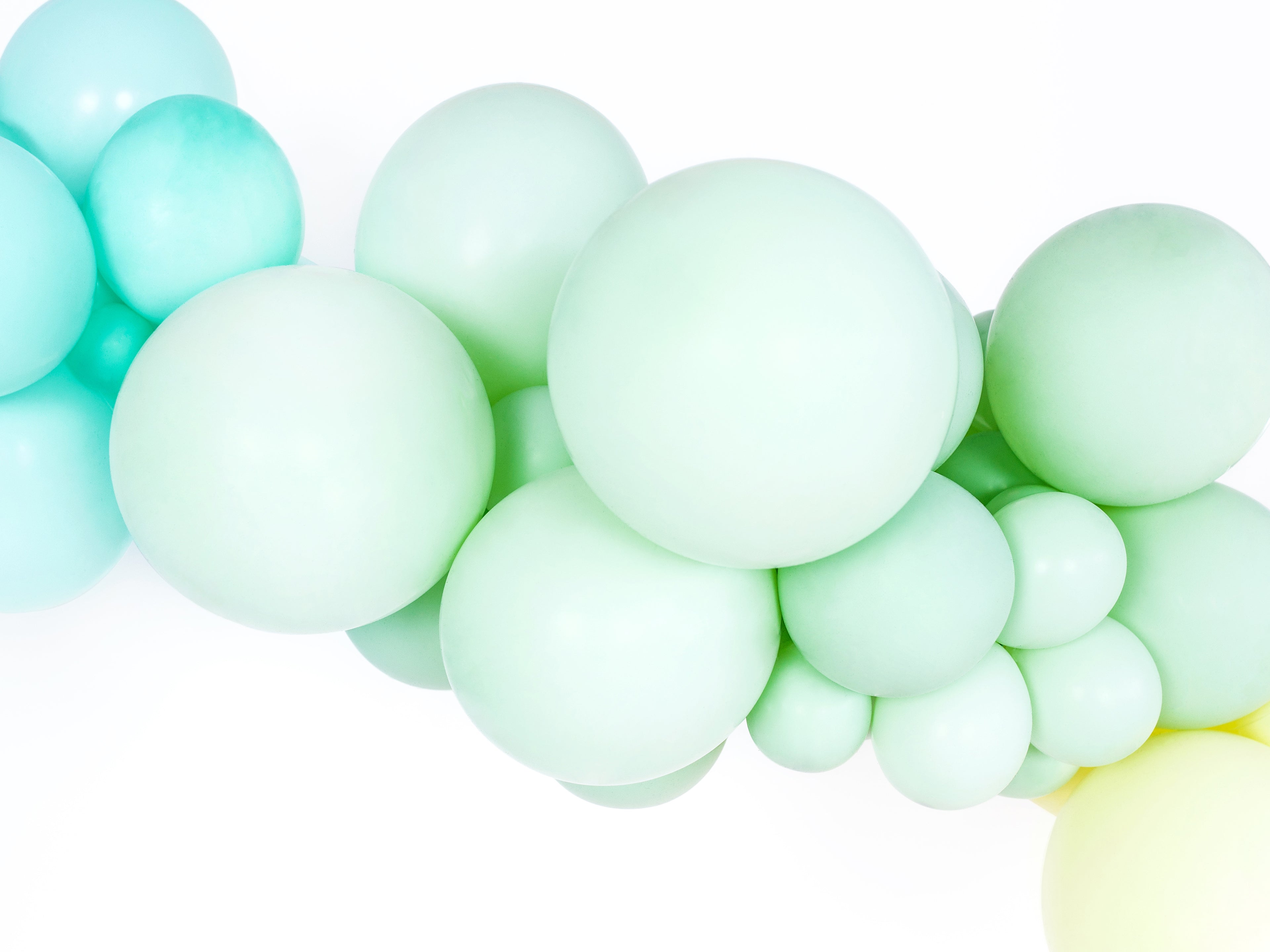 Close-up of light blue and green balloons on a white background