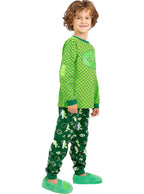 Besiruošiantis miegui berniukas su žaliais PJ Masks pižamos marškinėliais ir kelnėmis.