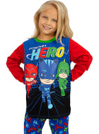 Mergaitė su „PJ Masks“ pižama, kurioje pavaizduoti animacinių filmukų herojai.