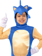 Besitęsiantis vaikas su mėlynu Sonic ežiuko kostiumu ir baltomis pirštinėmis.